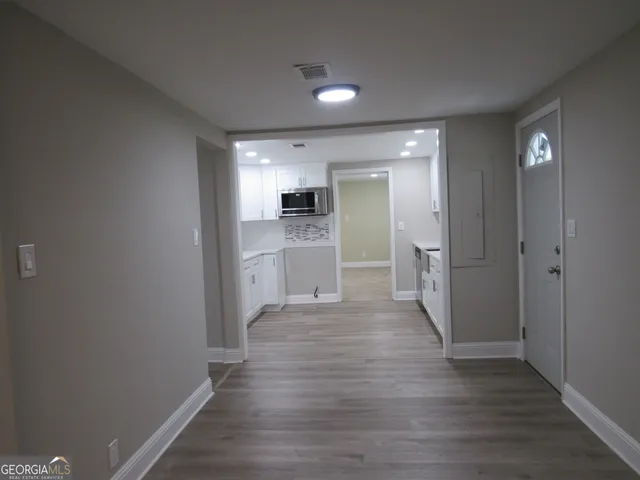 a view of wooden floor chandelier and window in a room