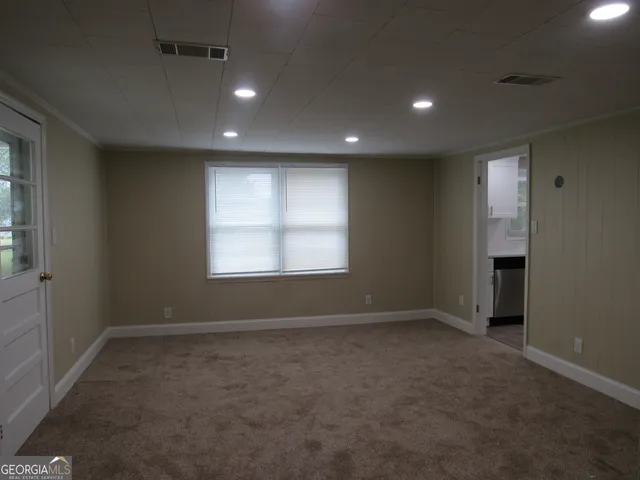 a kitchen with white cabinets and window