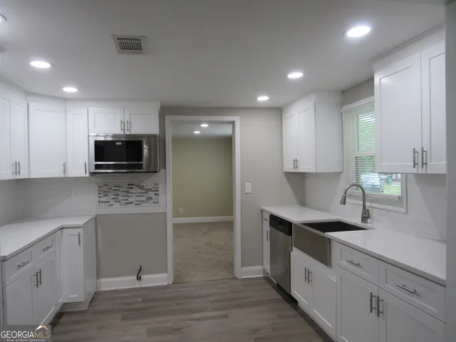 a kitchen that has a sink a stove and cabinets