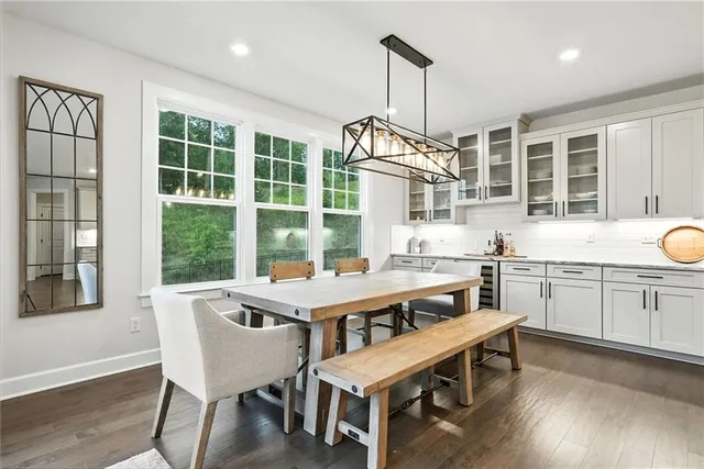 a kitchen that has a table chairs sink and wooden floor