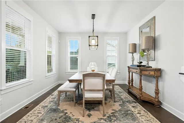 a dining room with furniture a chandelier and wooden floor