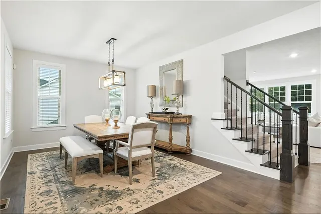 a dining room with wooden floor windows and a chandelier