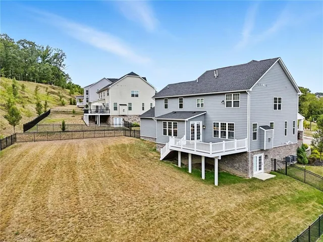 a view of a house with a wooden deck and a yard