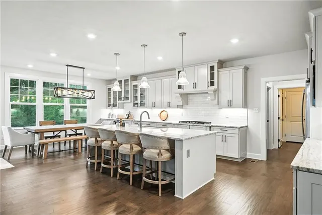 a kitchen with lots of wooden furniture appliances and dining table