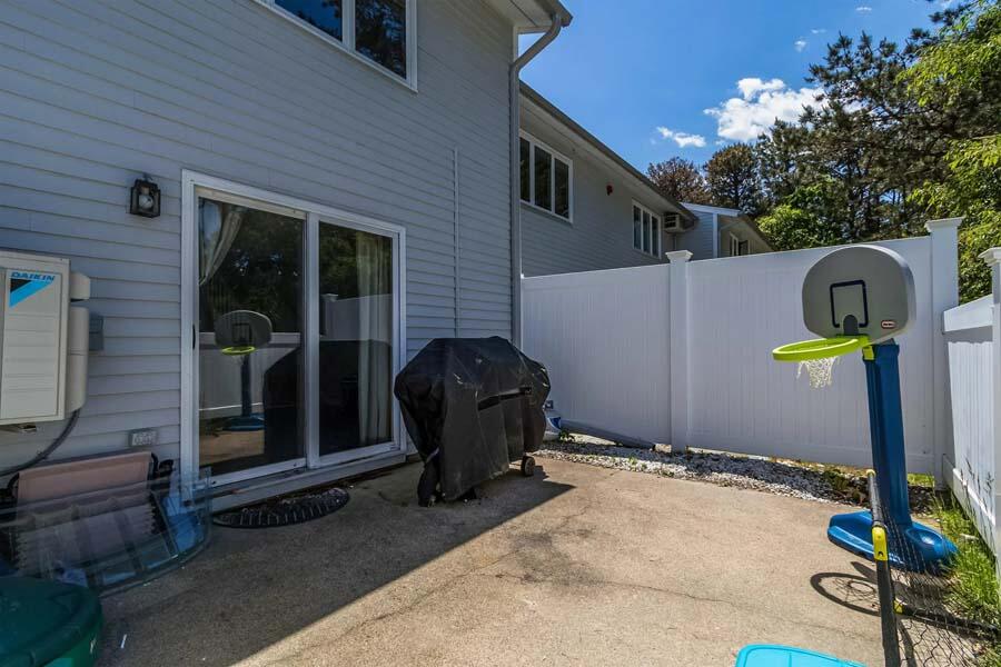 174 Lowell Road, Unit J117 Mashpee, MA 02649 - Photo 23 of 26 a backyard of a house with barbeque oven table and chairs