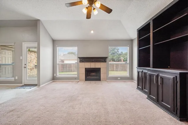 a living room with a fireplace and windows