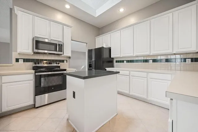 a kitchen with kitchen island a sink stainless steel appliances and cabinets