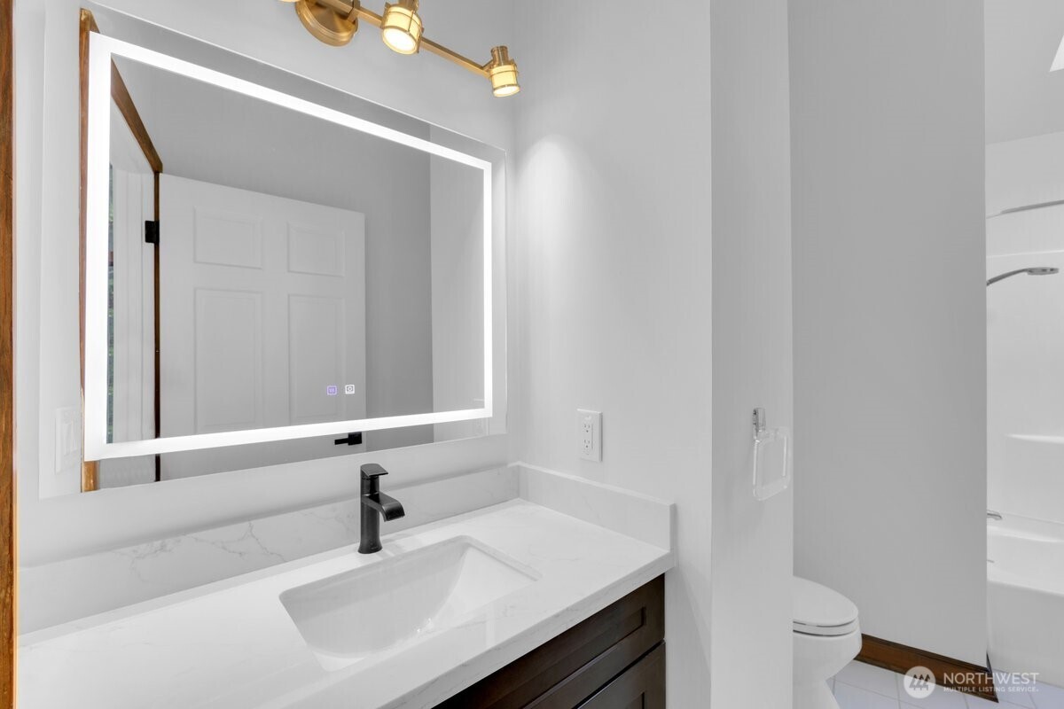 16015 Inglewood Road Northeast Kenmore, WA 98028 - Photo 19 of 37 a bathroom with a sink a toilet and a mirror