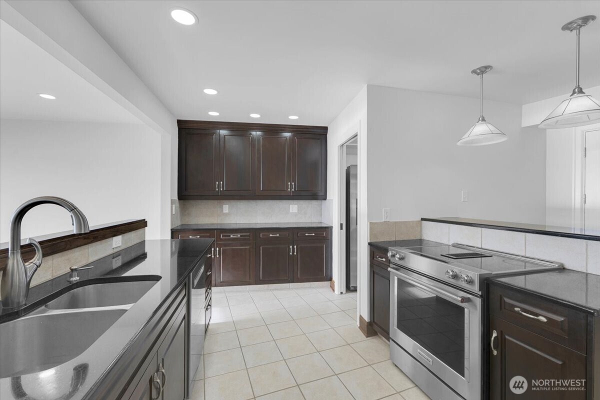 16015 Inglewood Road Northeast Kenmore, WA 98028 - Photo 10 of 37 a kitchen with granite countertop a sink stainless steel appliances and cabinets