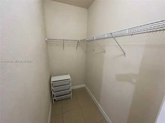 a view of walk in closet with racks on the wall