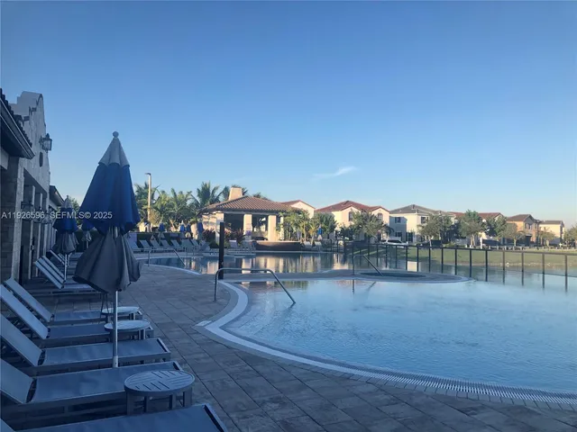 a view of swimming pool with outdoor seating and plants