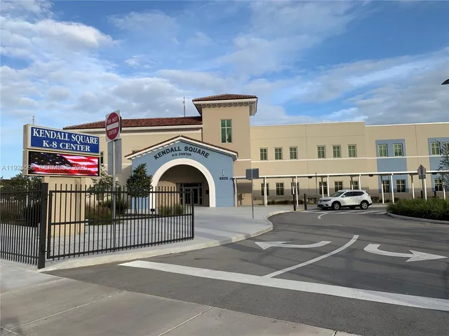 a view of building with cars parked