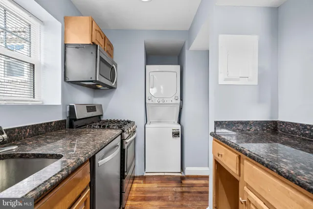 a kitchen with granite countertop a sink stove and refrigerator