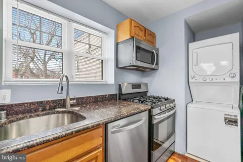 a kitchen with stainless steel appliances granite countertop a sink a stove and a microwave