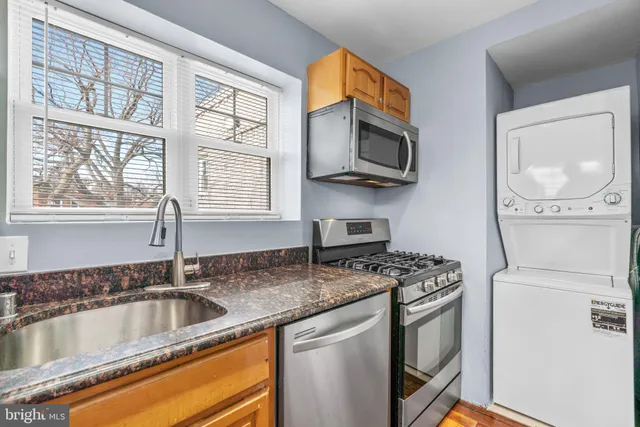 a kitchen with stainless steel appliances granite countertop a sink a stove and a microwave