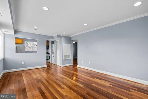 a view of an empty room with wooden floor