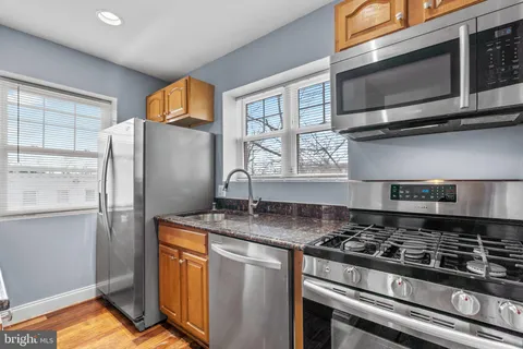 a kitchen with stainless steel appliances granite countertop a stove a refrigerator and a microwave