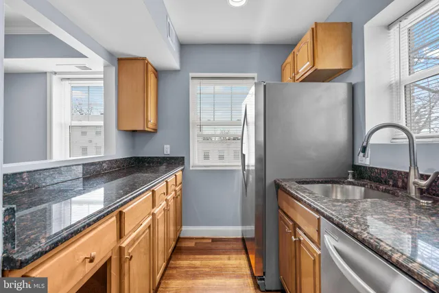 a kitchen with granite countertop sink and cabinets