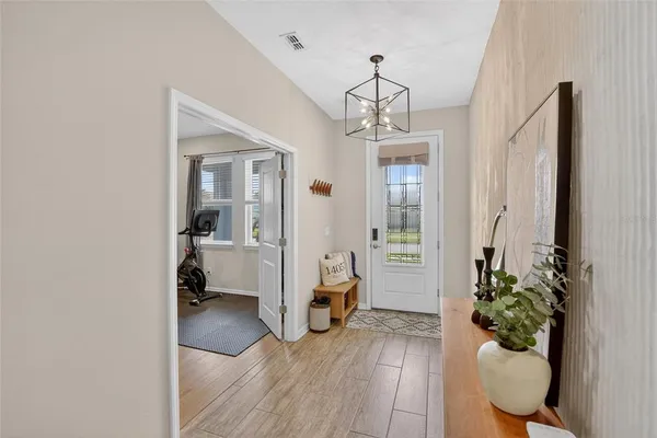 a kitchen with stainless steel appliances a stove a sink a dining table and chairs with wooden floor