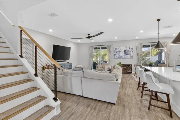 a kitchen with stainless steel appliances kitchen island a table chairs sink and cabinets