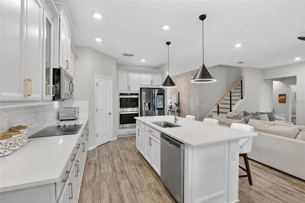 a living room with furniture and a view of kitchen