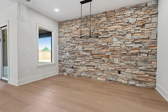 an empty room with wooden floor and ceiling fan
