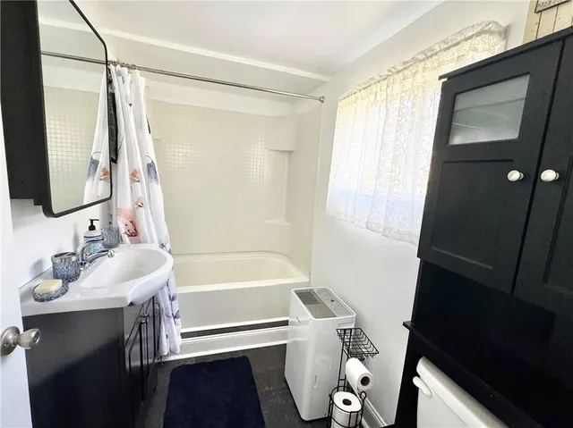 a bathroom with a sink a tub and a mirror