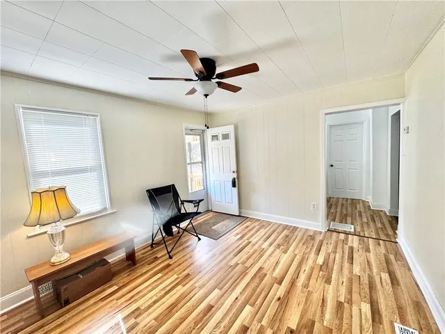 a view of a room with wooden floor and ceiling fan