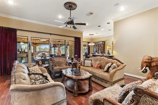 a living room with furniture ceiling fan and a large window