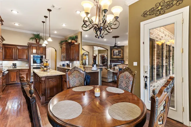 a view of a dining room with furniture a chandelier and wooden floor