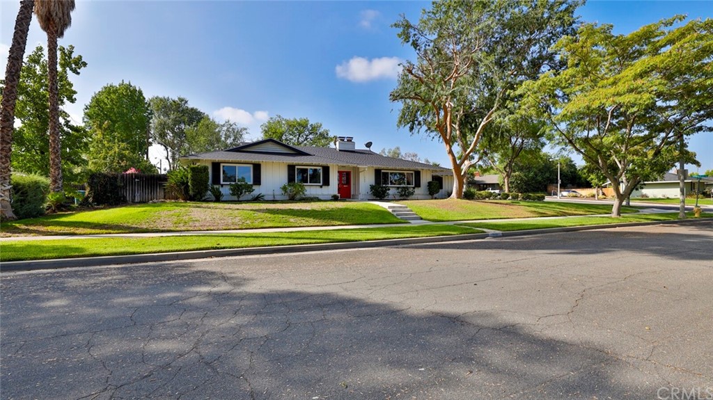 1980 Longmont Street Riverside, CA 92506 - Photo 1 of 1 a view of a white house with a big yard and palm trees