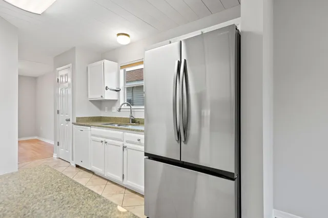 a view of a kitchen with a sink refrigerator and a window