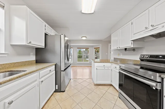 a kitchen with granite countertop white cabinets and appliances