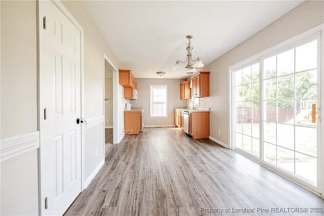 a view of a big room with wooden floor and windows