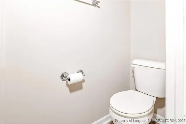 a white toilet sitting next to a white wall