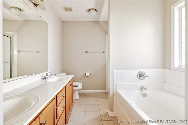 a bathroom with a tub sink and mirror