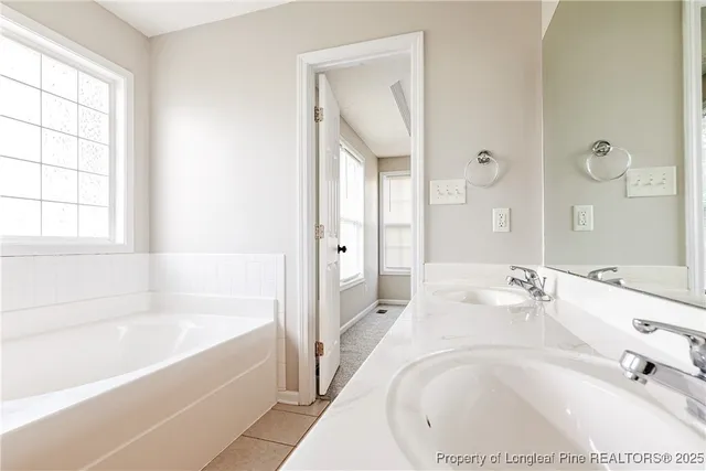 a bathroom with a tub sink and mirror