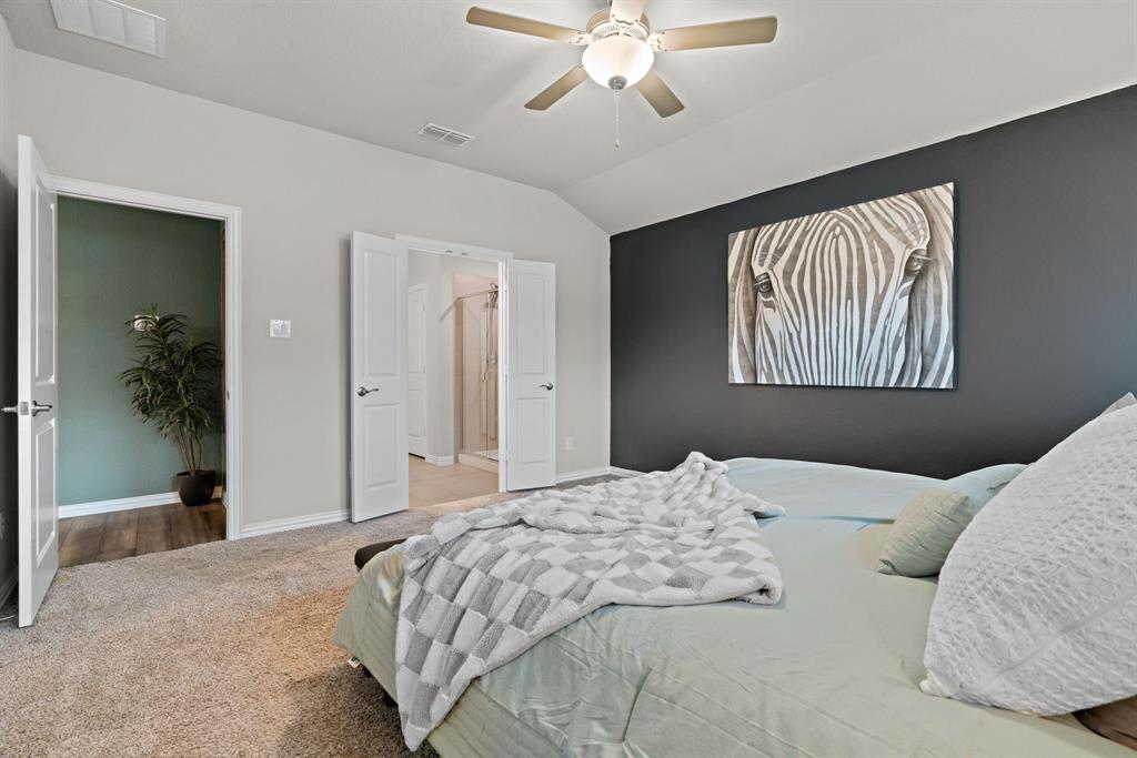 3112 Kingsgarden Road Denton, TX 76207 - Photo 28 of 38 Vaulted ceiling bedroom featuring a ceiling fan with integrated lighting, a dark accent wall, and plush carpeting