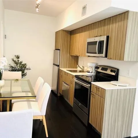 a kitchen with stainless steel appliances a stove a microwave a sink and a refrigerator