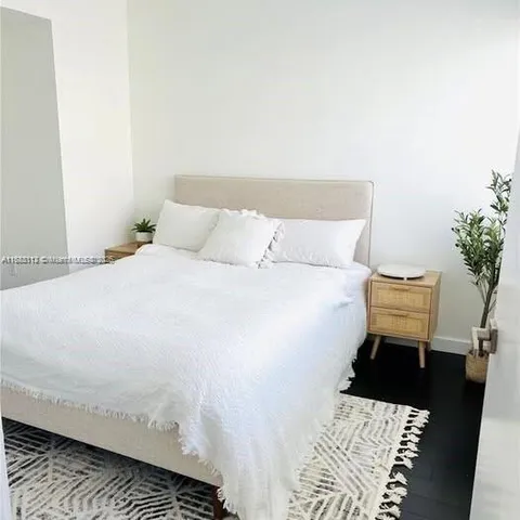 a bed room with a bed and a potted plant