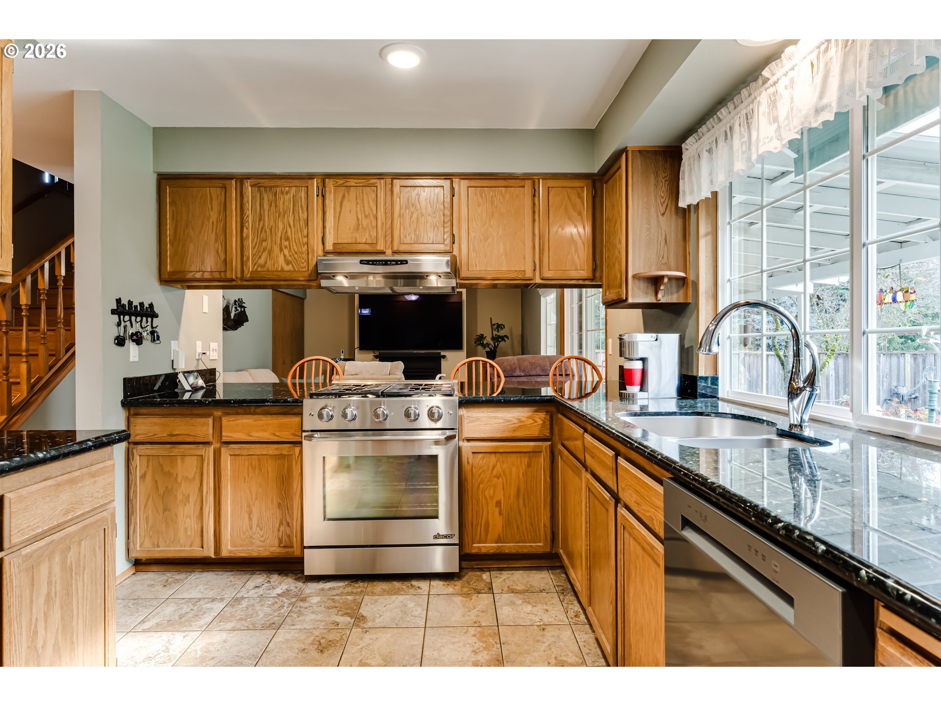 5131 Trevon Street Eugene, OR 97402 - Photo 12 of 42 a kitchen with kitchen island granite countertop a sink appliances cabinets and a large window