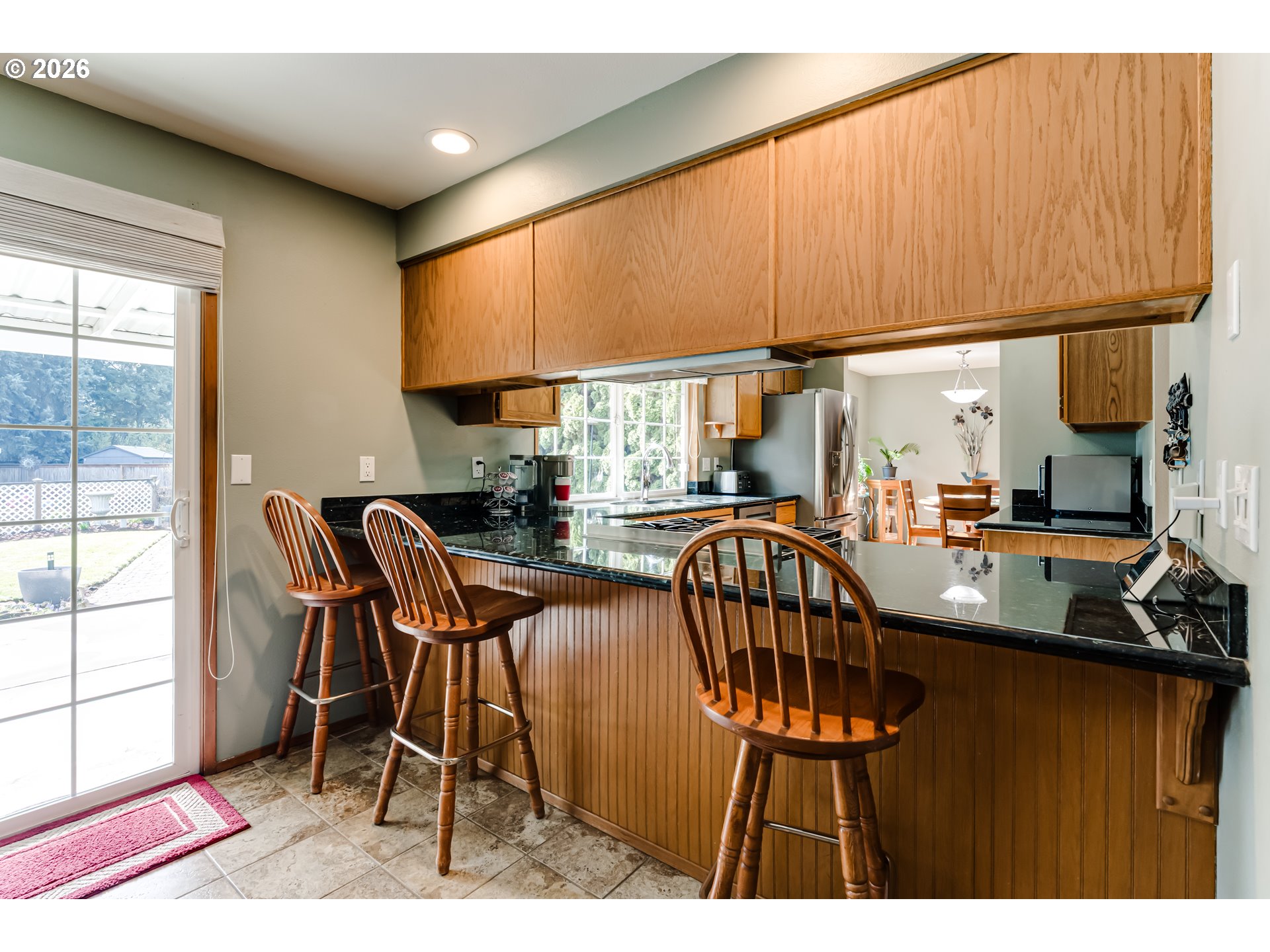 5131 Trevon Street Eugene, OR 97402 - Photo 19 of 42 a kitchen with stainless steel appliances dining table chairs and wooden cabinets