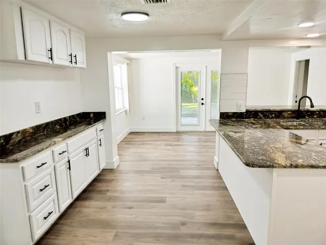 a large white kitchen with granite countertop white cabinets and a granite counter tops