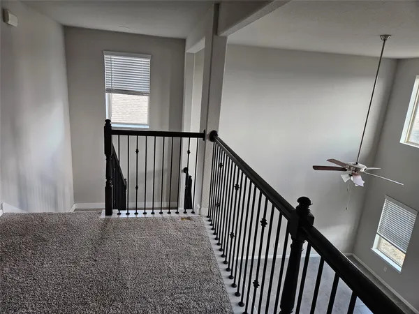 a view of a hallway with wooden floor and staircase