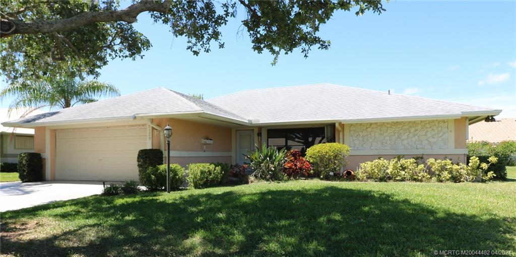 5139 Southeast Hanson Circle Stuart, FL 34997 - Photo 6 of 27 a front view of a house with a yard and potted plants