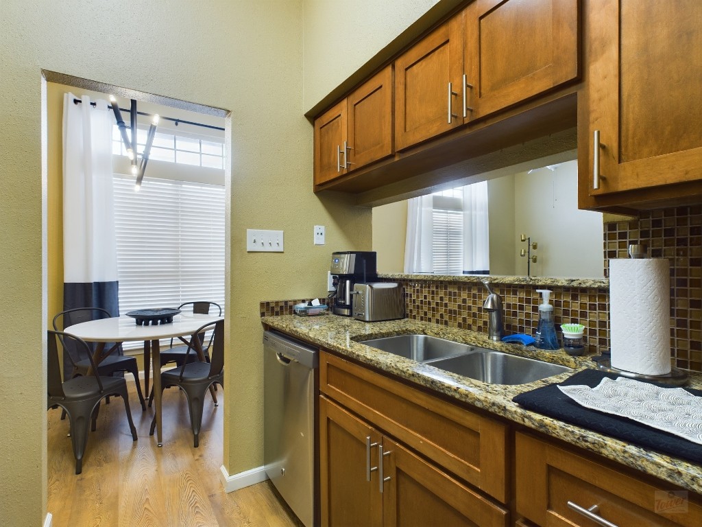 2811 Rio Grande Street, Unit 204 Austin, TX 78705 - Photo 10 of 31 a kitchen with stainless steel appliances granite countertop a sink a stove and a wooden cabinets