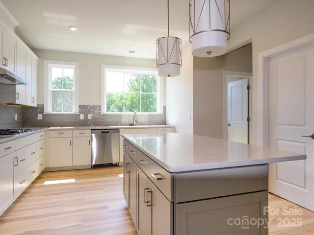 a kitchen that has a sink a window and stainless steel appliances