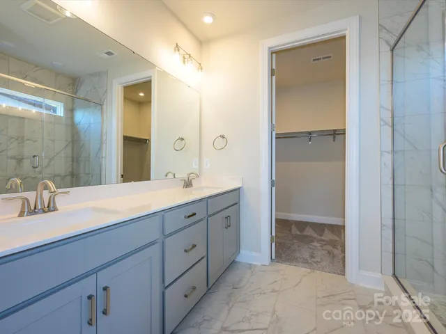 a spacious bathroom with a double vanity sink mirror and shower