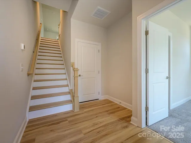 a view of a hallway with wooden floor and entryway