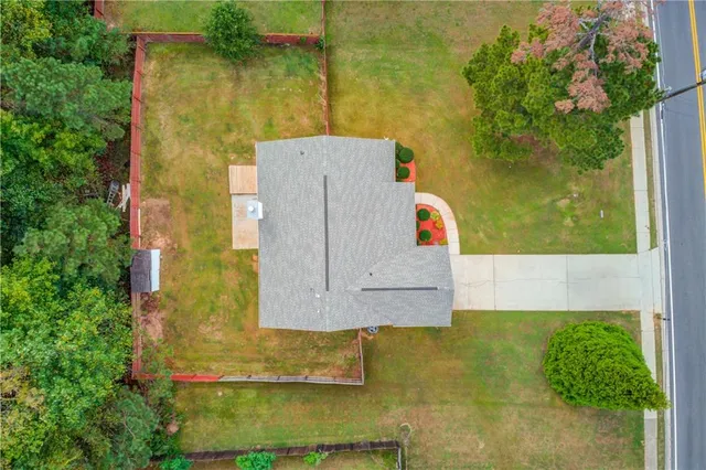 an aerial view of a house with a yard and large tree
